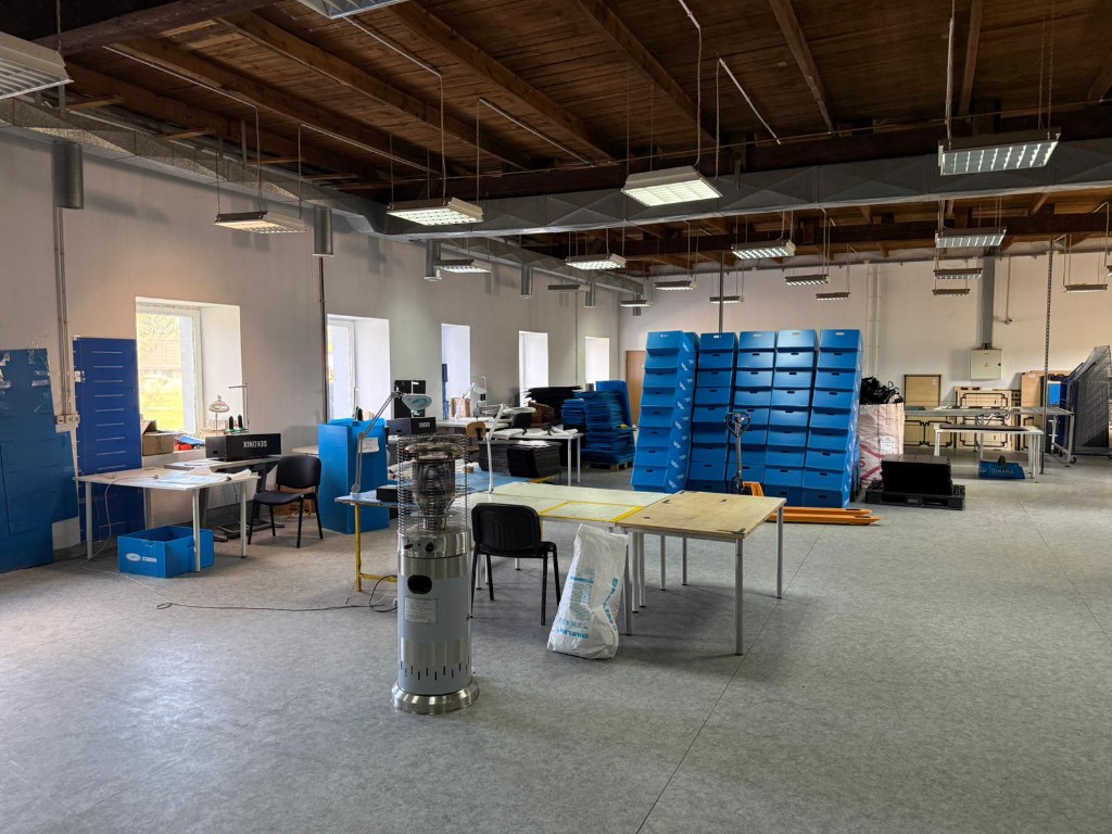 Corrugated plastic box production area with stacked blue boxes.