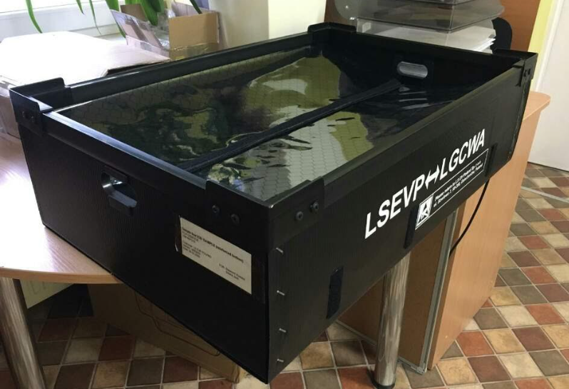 Large black corrugated plastic industrial box with reinforced corners and custom printed markings.