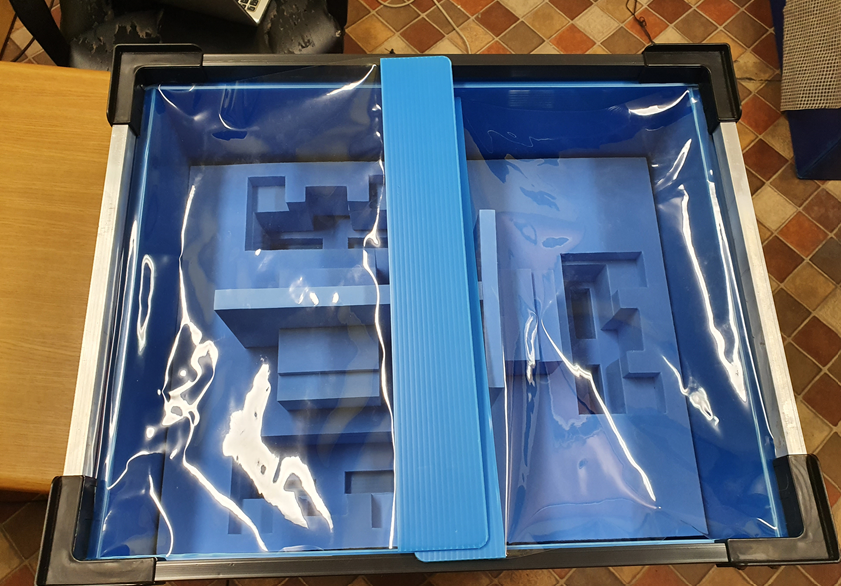 Bright green corrugated plastic container with a multi-compartment grid and reinforced rim.