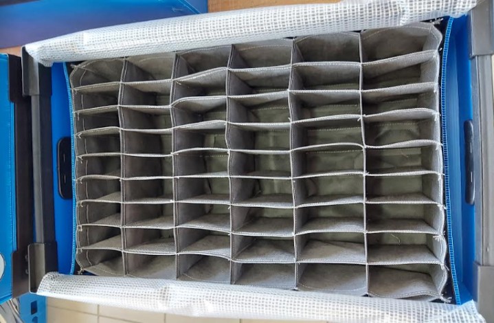 Blue corrugated plastic crates stacked on a modular pipe rack with roller track.