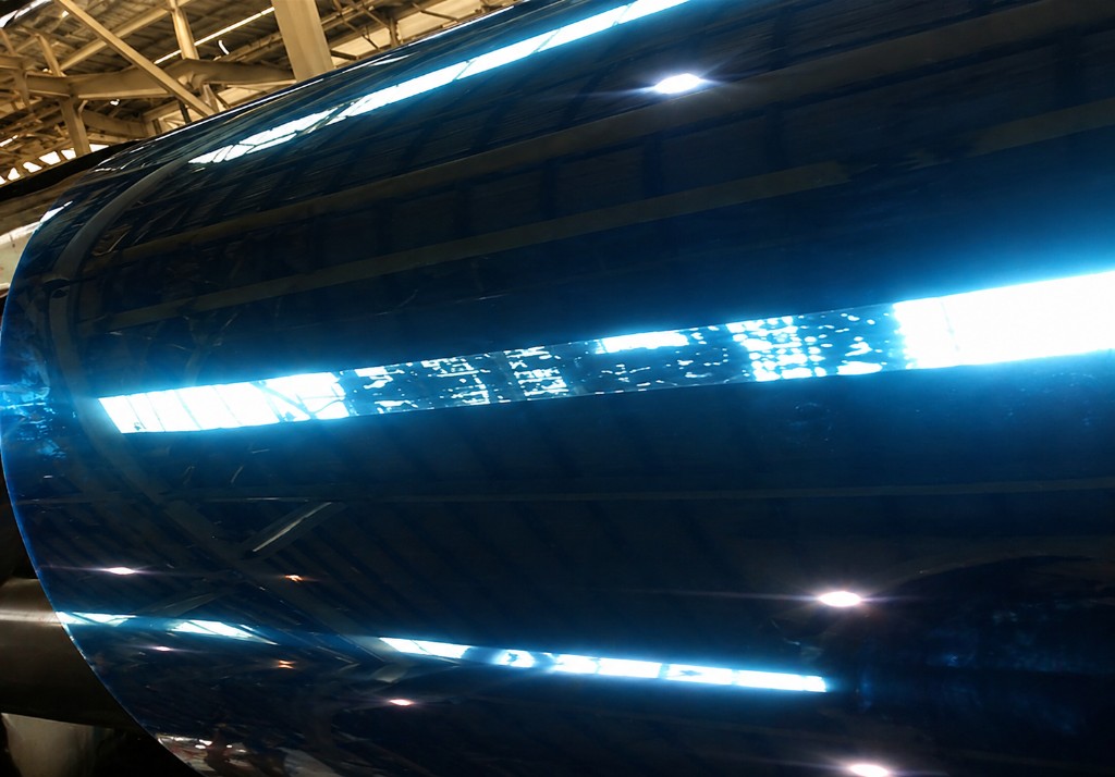 Blue protective film on a metal coil surface.