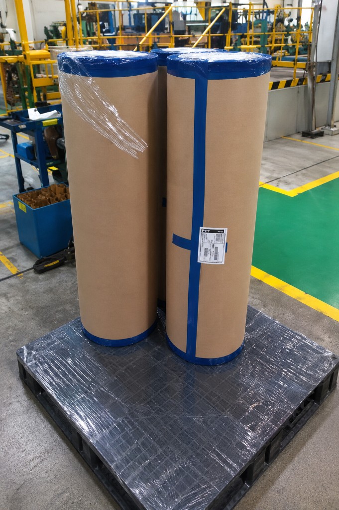 Large protective film rolls staged on a pallet in a factory.